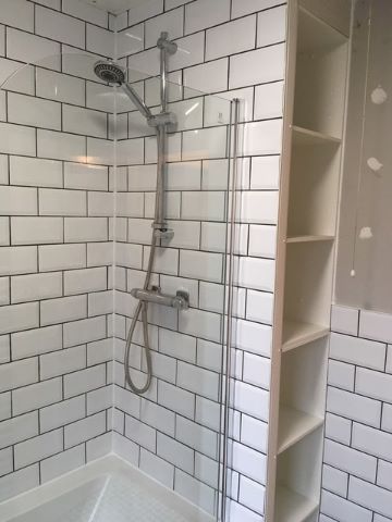 Shower with screen over bath and towel shelves